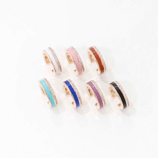 Eight enamel ear cuffs in various colors with crystal edges, displayed in neat grid on white background