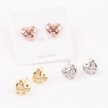 Flat lay of rose gold silver and gold puffy heart stud earrings with quilted matelassé pattern