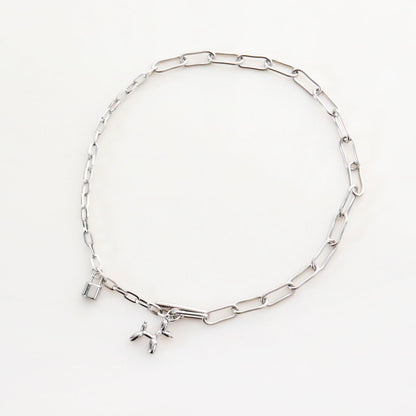 Flat lay of surgical steel toggle clasp necklace with paperclip chain and balloon dog charm