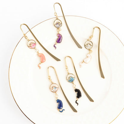Gold metal cat bookmarks with wave charms displayed in circular arrangement showing all five elegant colors