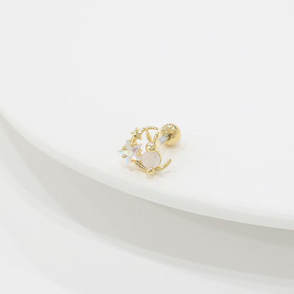 Single gold bunny moon barbell earring placed on a curved white plate, shot with soft shadows to highlight the iridescent stars and moon charm.