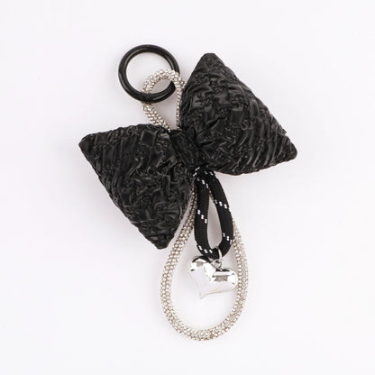 Textured black quilted bow keychain with crystal studded loop and silver heart pendant