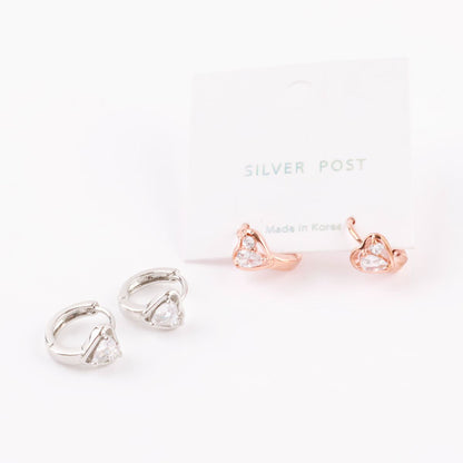 Two pairs of heart cubic zirconia huggie earrings in rose gold and silver, shown with and without packaging cards.