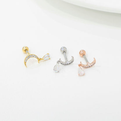 Flat lay of three crescent moon piercings showing surgical steel posts and teardrop dangles