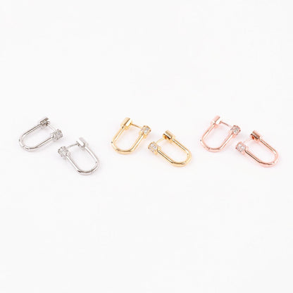 Three pairs of hoop earrings in silver, gold, and rose gold with pavé cylinder clasps arranged side by side on a white background.