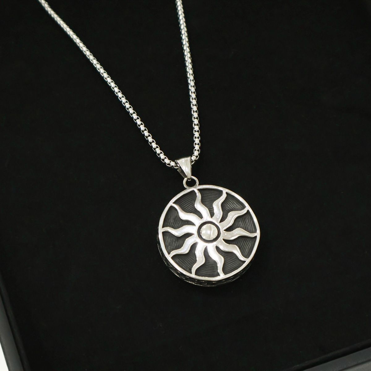 Sun symbol pendant necklace with black enamel detail closeup