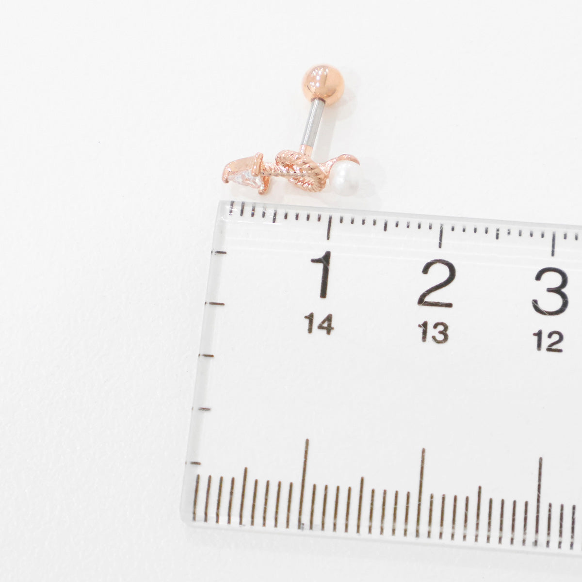 Size reference photo: rose gold arrow pearl drop helix stud next to measuring ruler showing 8mm total length