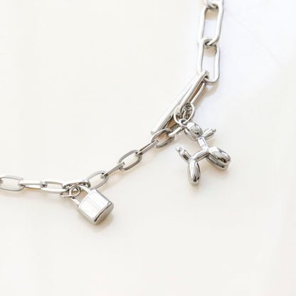 Detail shot of 3D balloon dog charm and mini padlock on mixed chain necklace