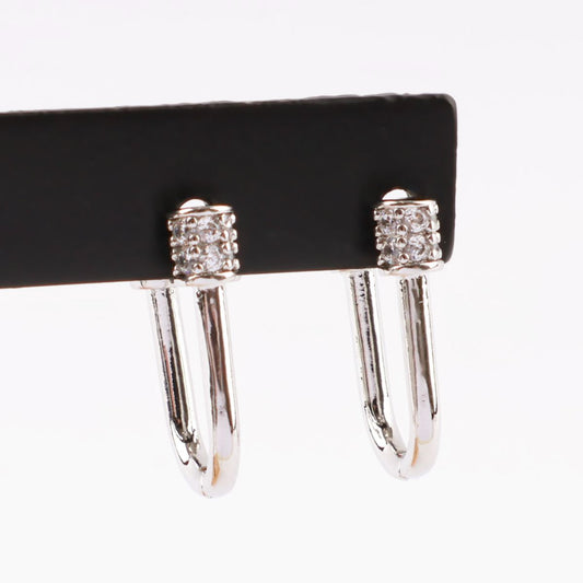 Silver pavé hoop earrings displayed on a black holder, showcasing the crystal cylinder clasp in detail.