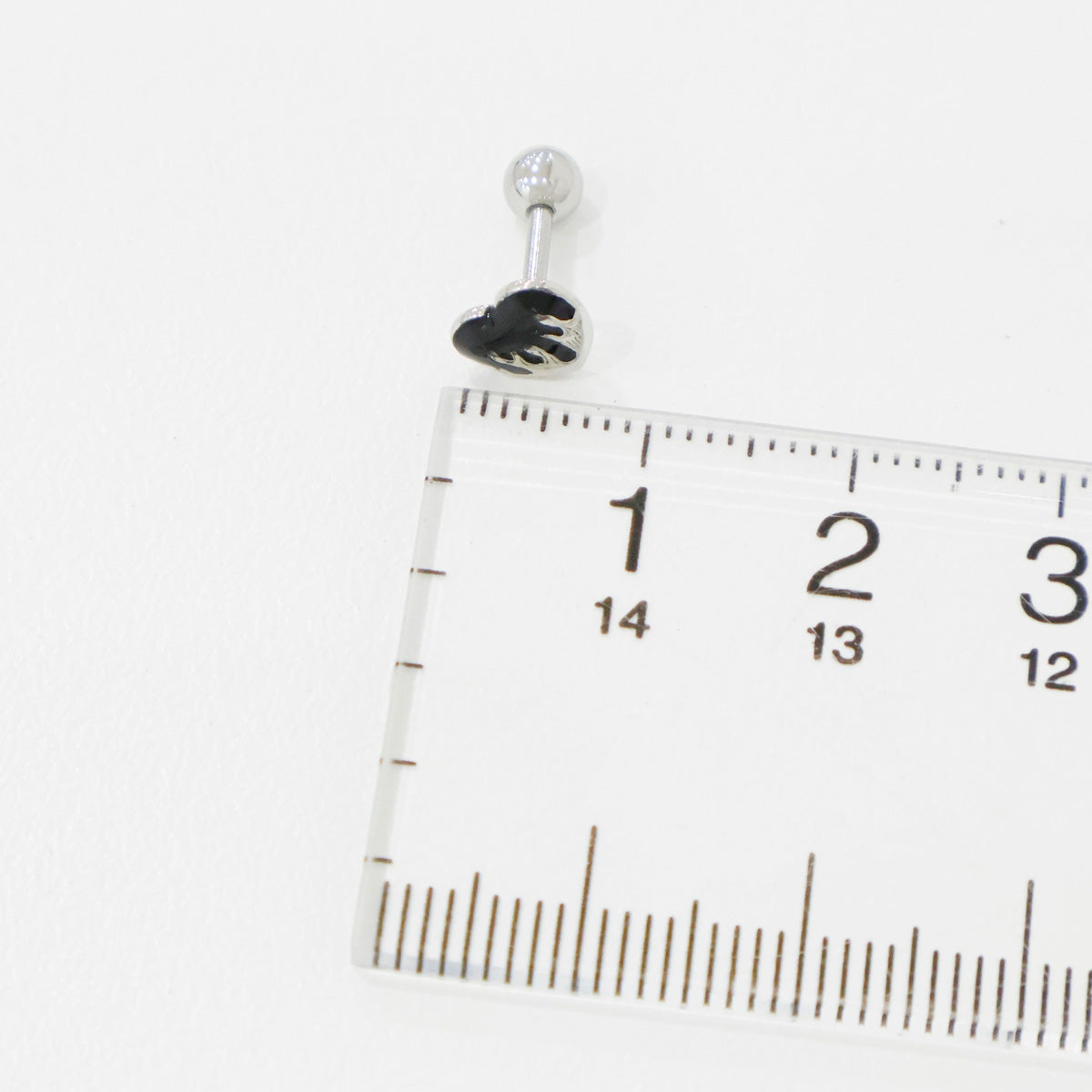 Black melting heart piercing with ruler showing 6-7mm size measurement