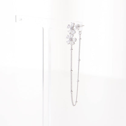 Single silver floral crystal ear jacket with chain displayed on white