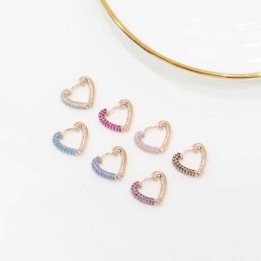 Set of heart-shaped earrings with colorful stones on a white background