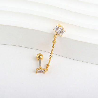 Close-up product detail showing surgical steel post and brass chain with crystal
