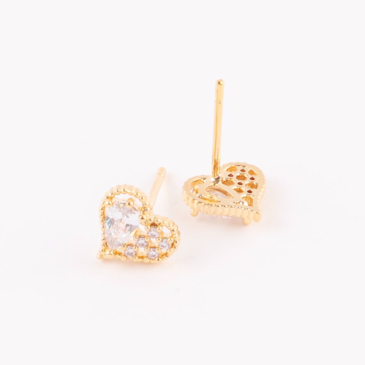 Gold heart-shaped earrings with detailed back setting shown flat on a white surface, showcasing front and back view.