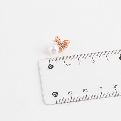 Pearl bow earring size measurement with ruler showing 1.5cm height