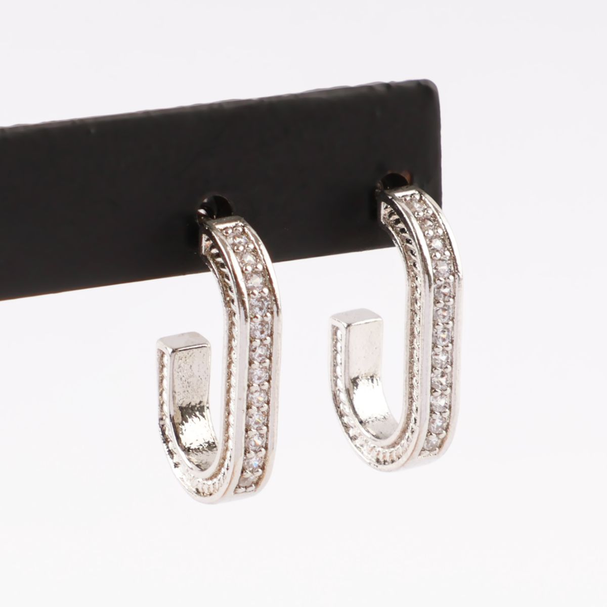 Silver oval drop stud earrings on black display stand