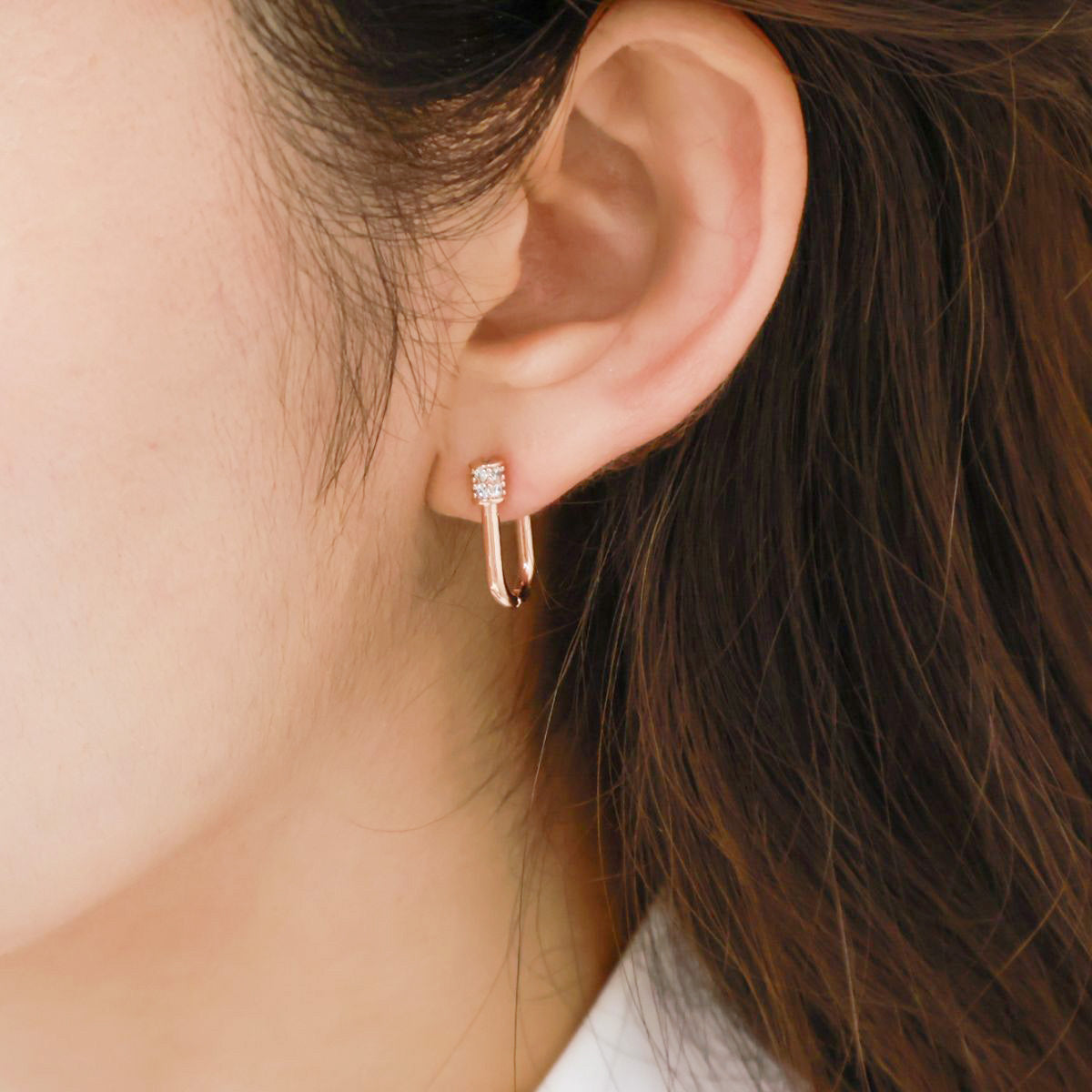 Rose gold pavé hoop earrings worn on ear, showing elegant minimalist styling.