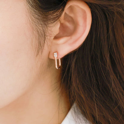Rose gold pavé hoop earrings worn on ear, showing elegant minimalist styling.