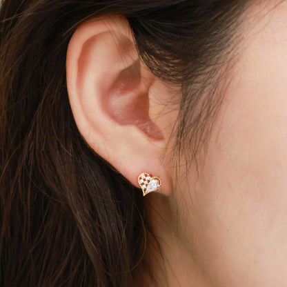 Close-up of a gold heart stud earring worn on the earlobe, styled alone for an elegant minimalist look.