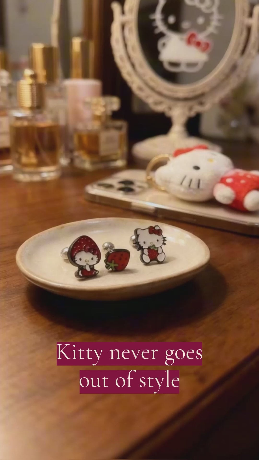 Hello Kitty strawberry surgical steel barbell earring set featuring three enamel designs on white background, strawberry costume Kitty, mini strawberry fruit, and sitting Kitty with strawberry, black metal borders with red enamel and green accents, 16G surgical steel barbells with ball studs, hypoallergenic piercing jewelry, Korean handmade Sanrio character piercings