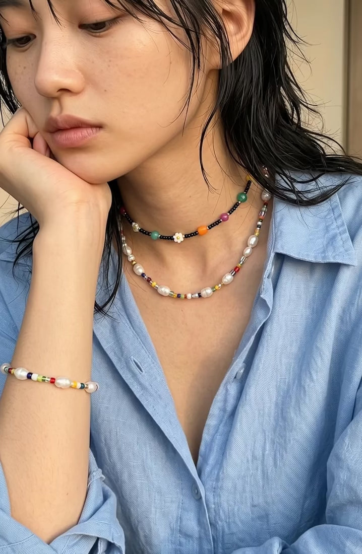 Coquette-coded necklace layering — 8ttitto8 pearl bead necklace with black seed bead choker, linen shirt vacation styling inspo