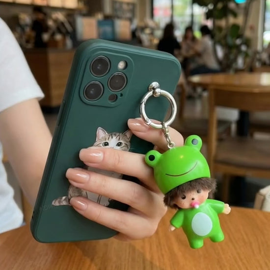 Frog baby doll keychain resting on iPhone at golden hour cafe window cozy aesthetic flatlay