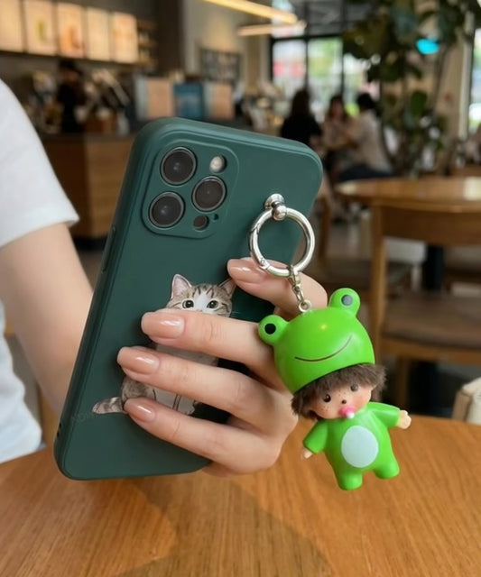 Frog baby doll keychain resting on iPhone at golden hour cafe window cozy aesthetic flatlay